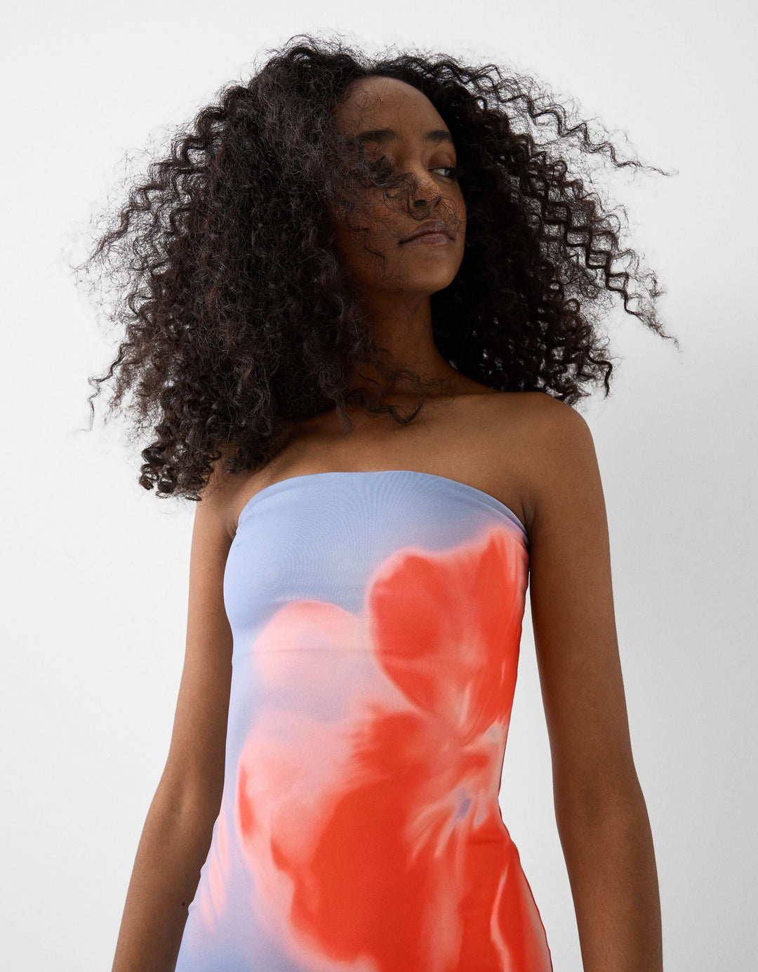 Fashionable women's floral strapless bandeau midi dress. Elegant summer holiday or party outfit.