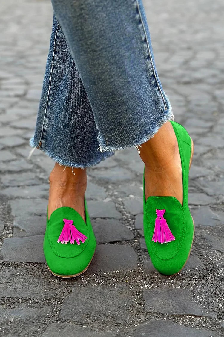 Green women's tassel loafers with a flat sole, offering effortless slip-on comfort and elegant casual style for everyday wear.