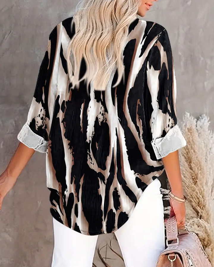 Women's stand collar irregular printed blouse with long raglan sleeves & button details.
