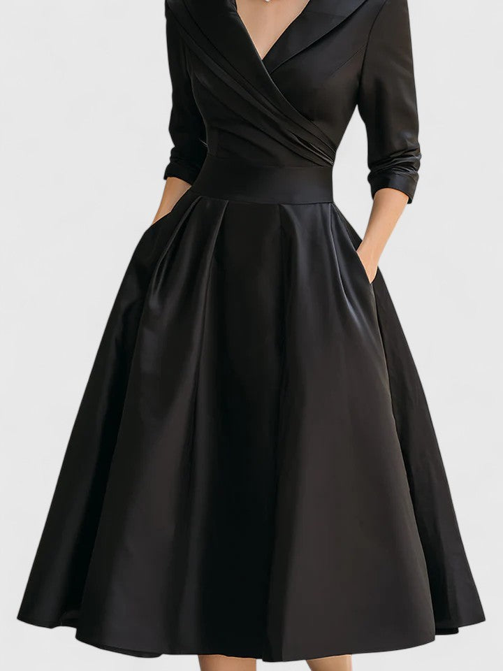 Detailed view of the graceful pleats & flared skirt of this elegant women's midi occasion dress.