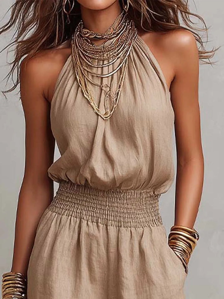 Summer holiday fashion: Sleeveless women's wide-leg jumpsuit with halter neck & smocked waist.