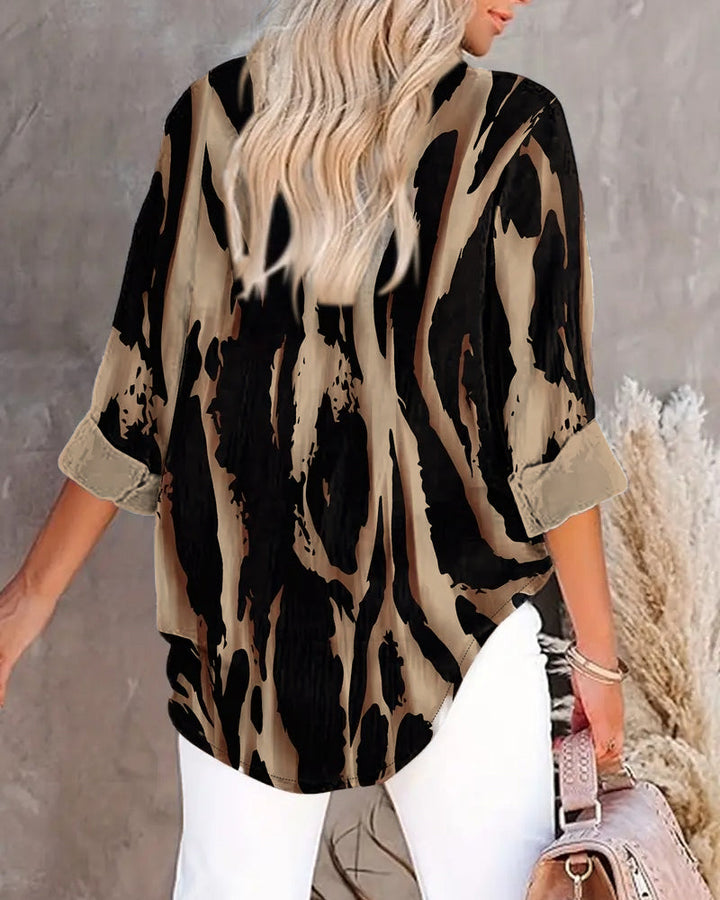 Close-up: Stand collar & unique irregular print on a women's long sleeve casual blouse.