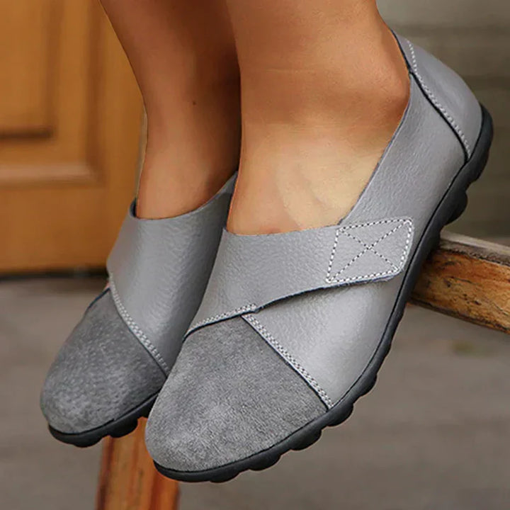 Comfortable unisex slip-on flats with stitched panels and a classic round toe, ideal for walking.