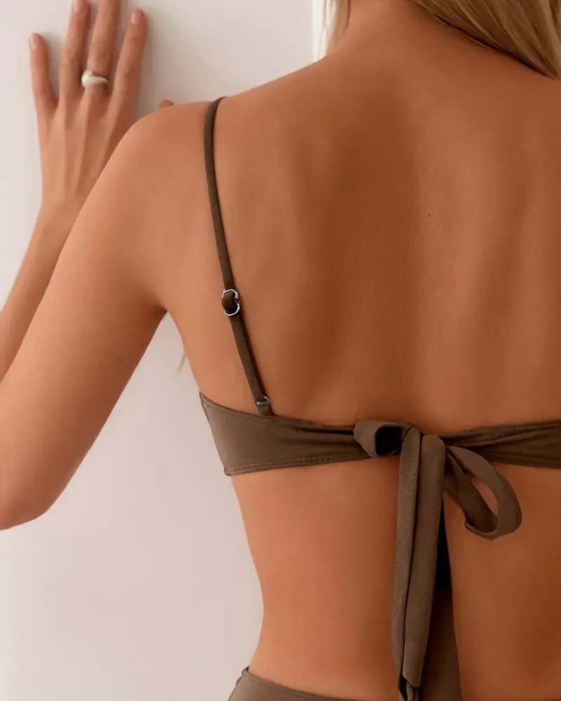 Chic women's two-piece bikini swimsuit, high-waisted bottom, and top with gold accents for summer.