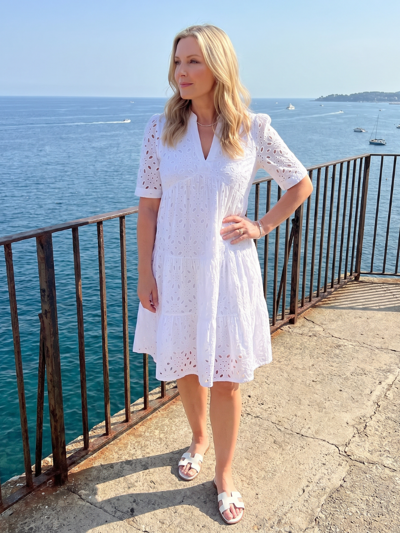 Comfortable relaxed fit women's short sleeve eyelet dress, knee-length, with V-neck and tiered skirt for summer days.