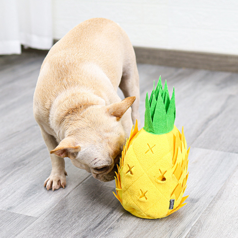 Yellow pineapple dog puzzle toy dispenses treats, providing mental stimulation & interactive play for canines.