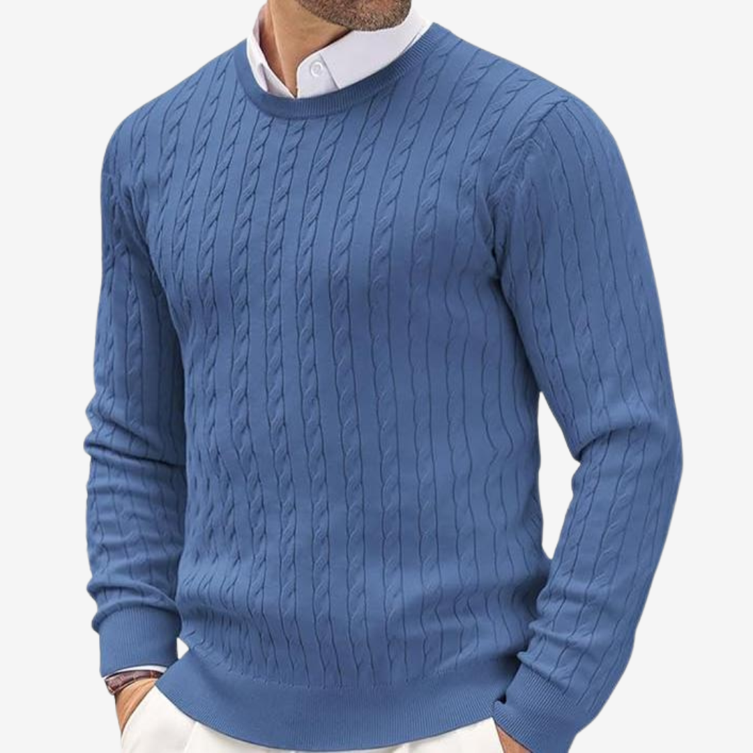 Man in a fitted cable knit crew neck sweater. Warm, classic men's knitwear for winter style.