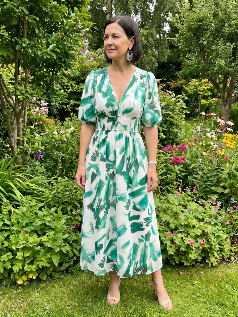Detailing abstract patterns and puff sleeves on this elegant women's V-neck midi dress for spring fashion.