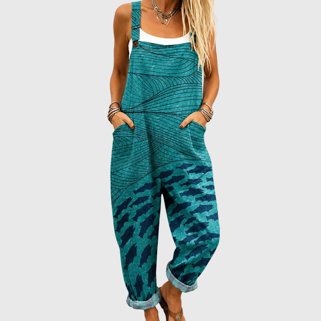 Women's turquoise ocean wave jumpsuit with a relaxed fit, adjustable straps, and pockets, perfect for summer vacation & resort wear.