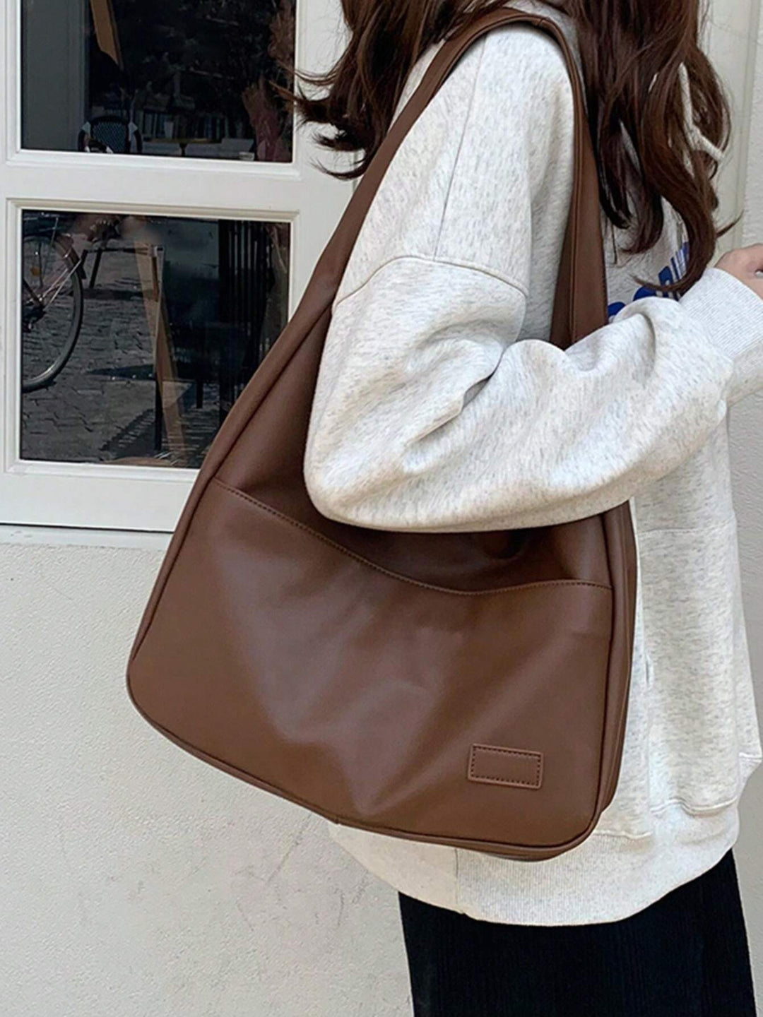 Close-up of women's vegan leather everyday shoulder bag texture. Durable & chic design for work/school.