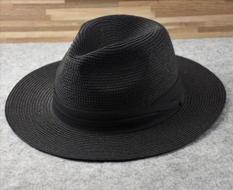 Women's straw wide brim beach hat, ideal for vacation. Chic Panama style summer accessory providing sun protection.