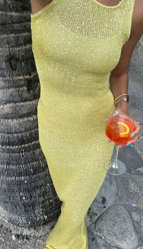 Sleeveless design of a women's shimmering yellow maxi dress, an elegant party wear evening gown.