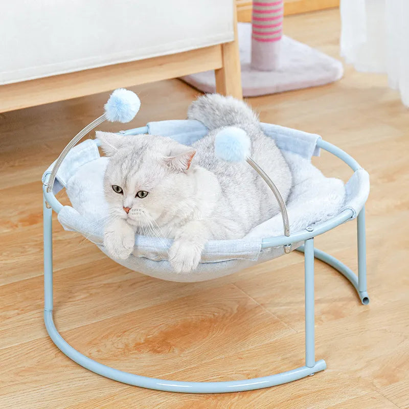 Comfortable round cat hammock with soft fabric and attached play balls for feline relaxation & play.