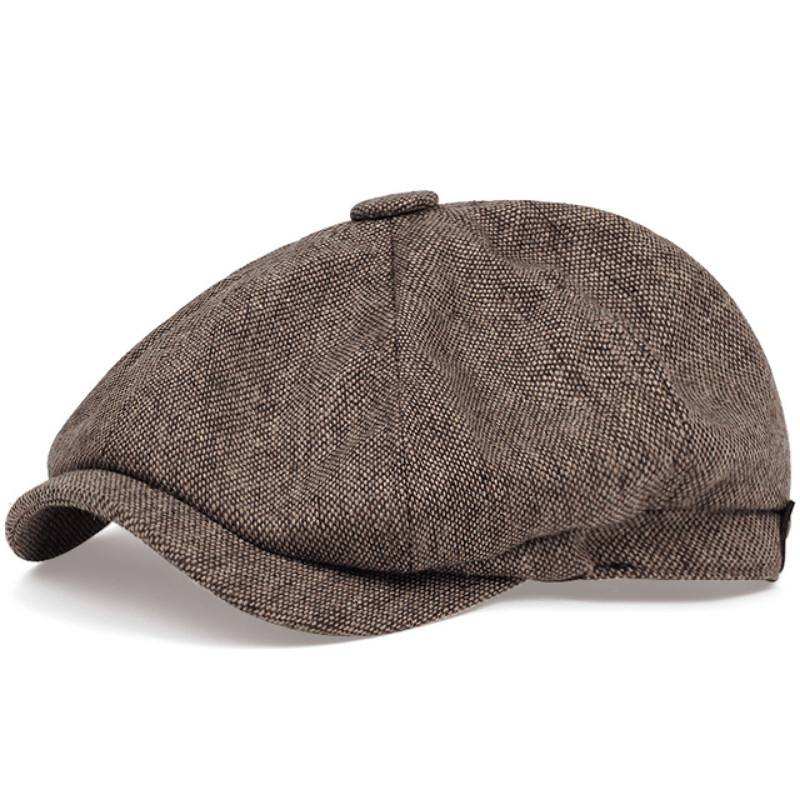 Man wearing a retro flat cap with herringbone pattern, classic driving cap style.
