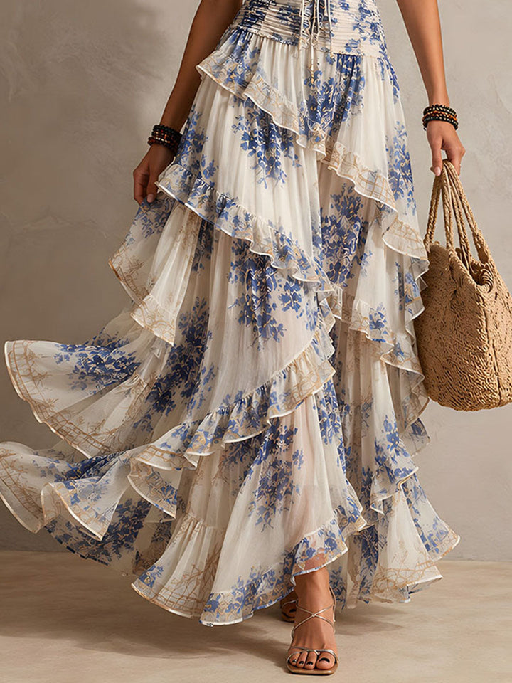 Flowy women's boho blue floral halter maxi dress, featuring elegant tiered ruffles. Comfortable summer resort wear.