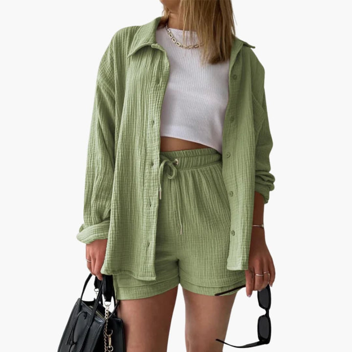 Women's resort wear three-piece outfit: flowy button shirt, crop top & breezy high-waist shorts. Vacation style.