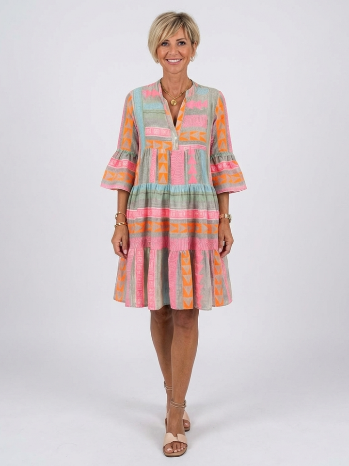 Women's pink geometric print V-neck tiered knee-length dress, perfect for casual summer day wear.