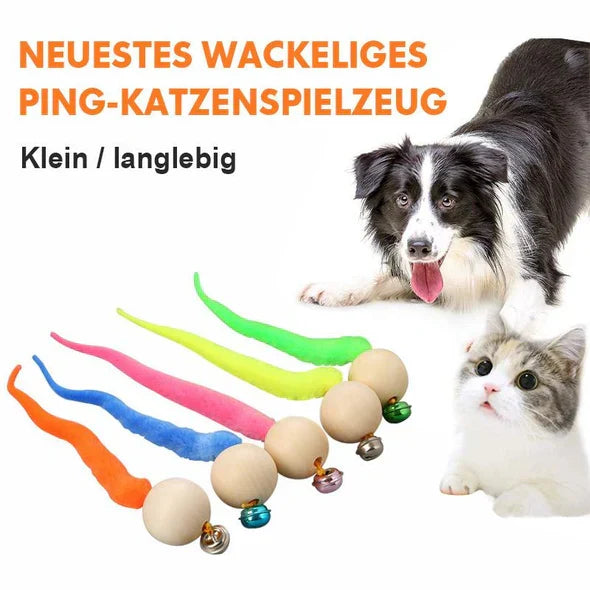Playful cat batting at an interactive wagging tail & bell toy. Promotes pet play & exercise.