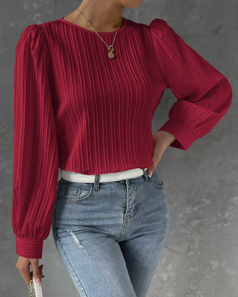 Model wearing a stylish white women's long sleeve round neck shirt, showcasing versatile fashion.