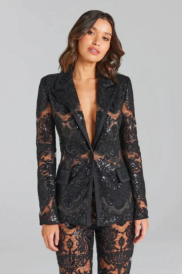 Chic women's two-piece fashion suit with a tailored white blazer and stylish flared trousers, party ready.