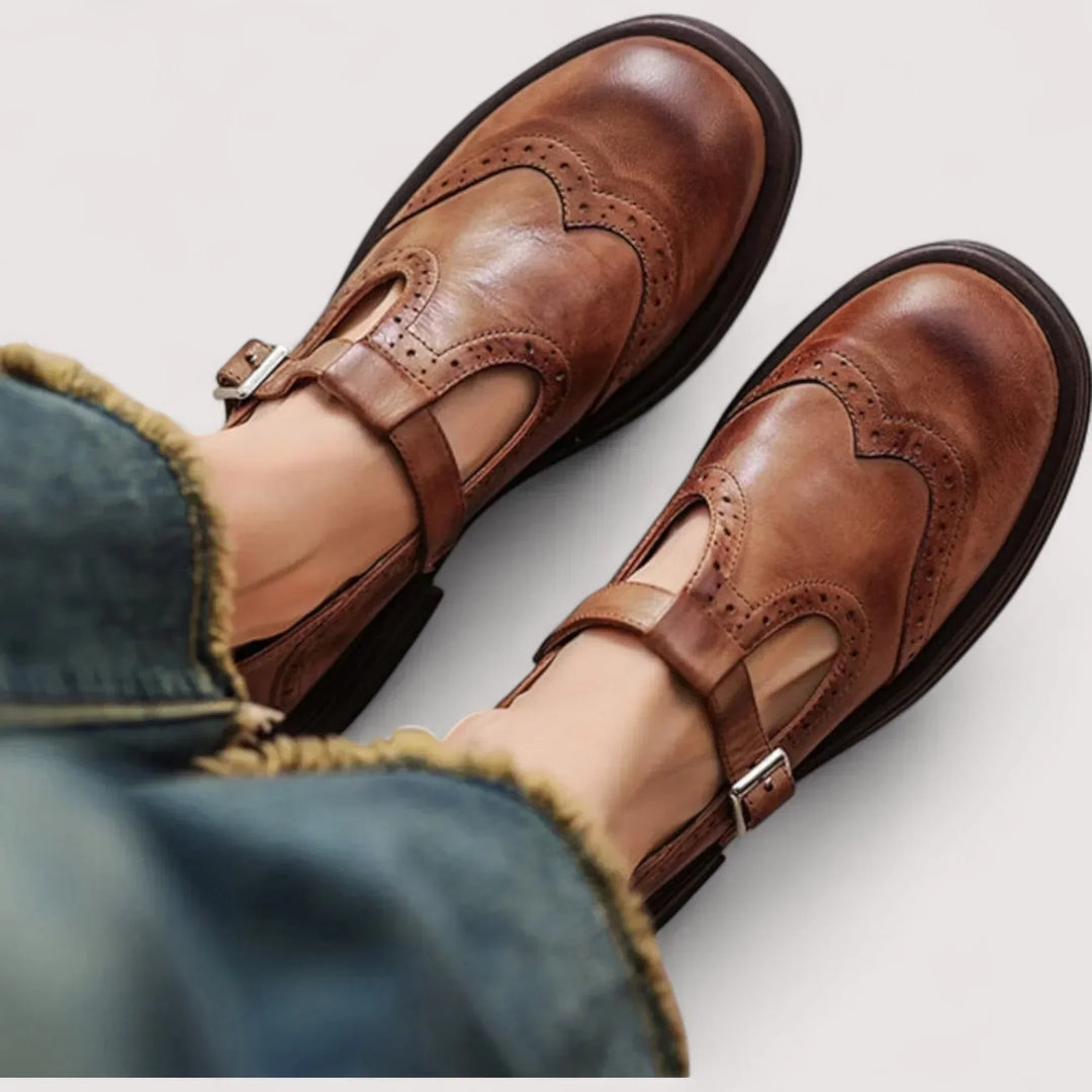 Classic women's black Mary Jane shoes with elegant brogue detailing & comfortable strap for vintage style.