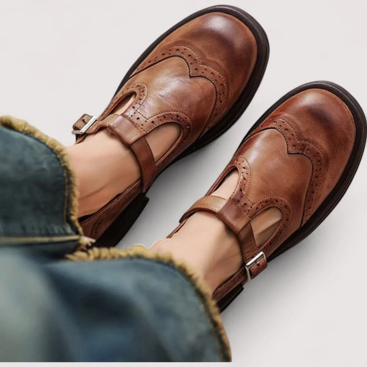 Classic women's black Mary Jane shoes with elegant brogue detailing & comfortable strap for vintage style.