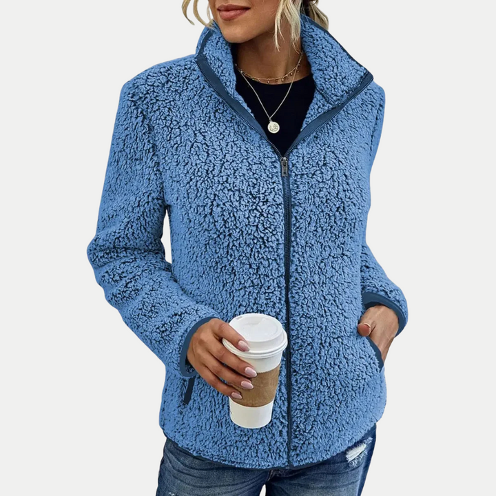 Women's zip-up fleece jacket with textured pattern, high collar, long sleeves. Casual and comfortable everyday wear.