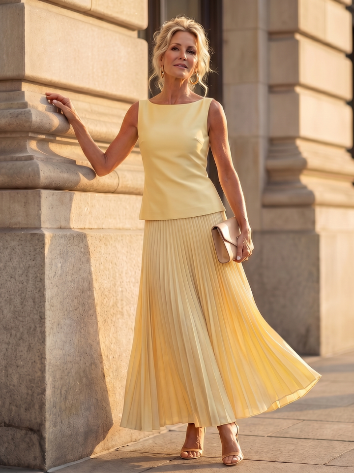 Elegant women's two-piece set featuring a structured bodice and a flowing pleated long skirt, perfect for parties.