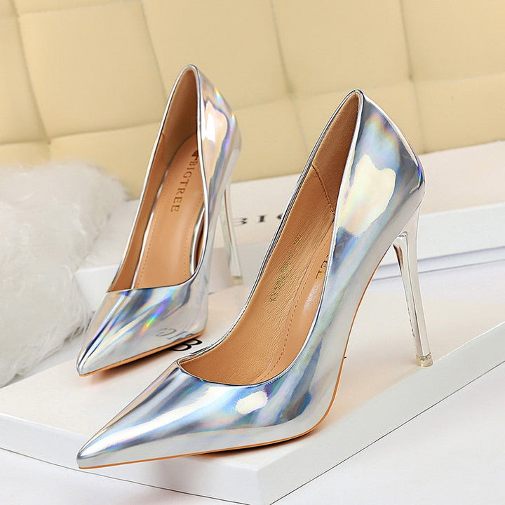 Woman showcasing black pointed toe high heel pumps, confident and elegant stance.