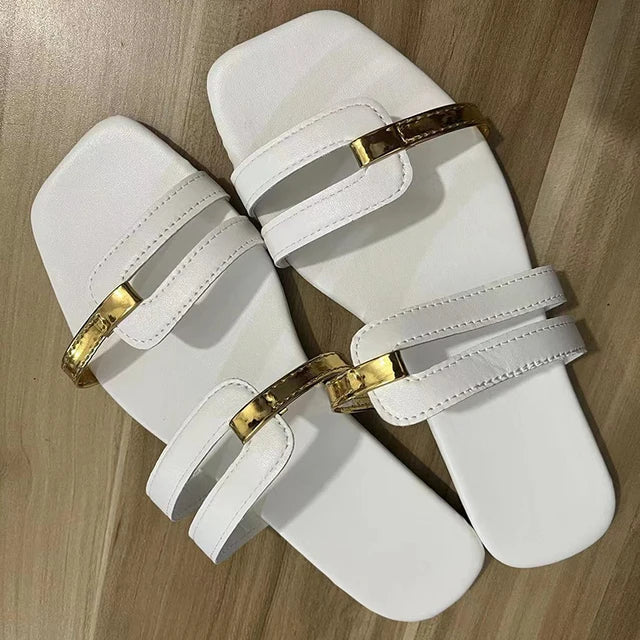 Stylish women's flat sandals with sleek double straps and gleaming gold detailing, comfortable.