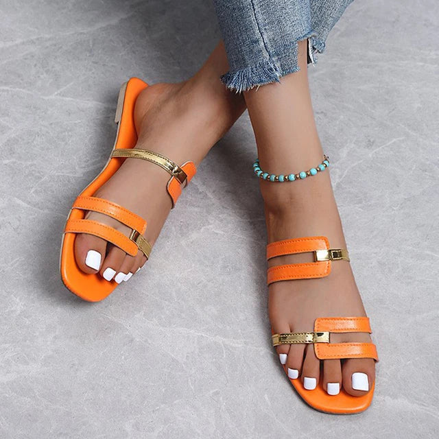 Trendy women's flat slide sandals with gold detail & double straps for chic summer comfort.