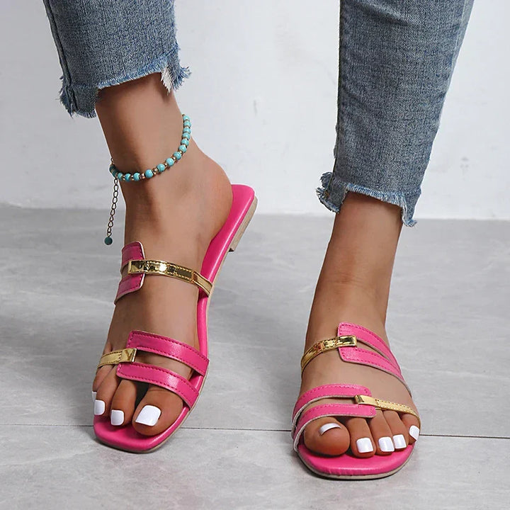 Women's fashionable flat sandals featuring double straps with elegant gold details, perfect for summer.