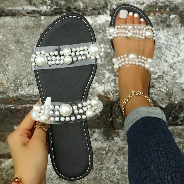 Stylish women's pearl strap transparent flat slides, ideal for summer parties, vacation, or casual wear.