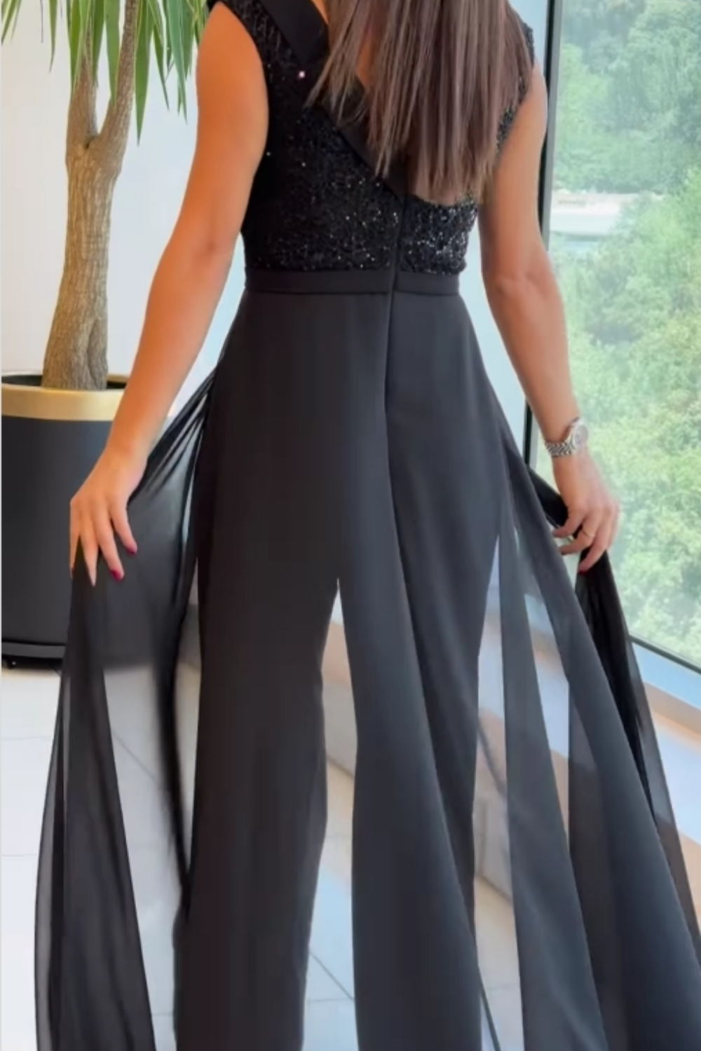 Sleeveless black sequin jumpsuit for women, featuring a straight leg & elegant bodice, ideal for parties.