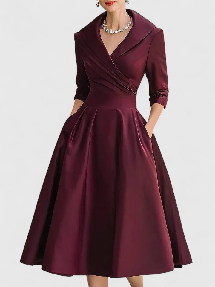 Model moving in an elegant women's pleated flared midi dress with wrap bodice, perfect for any occasion.
