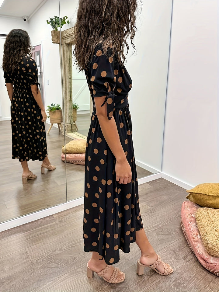 Sophisticated black polka dot midi dress for women. Designed with a chic v-neck and versatile tie sleeves, ideal for events.