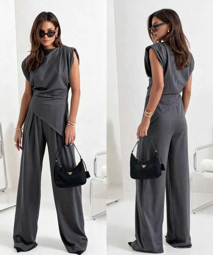Versatile women's two-piece set, a draped blouse with flowy wide-leg pants. Elegant summer outfit.