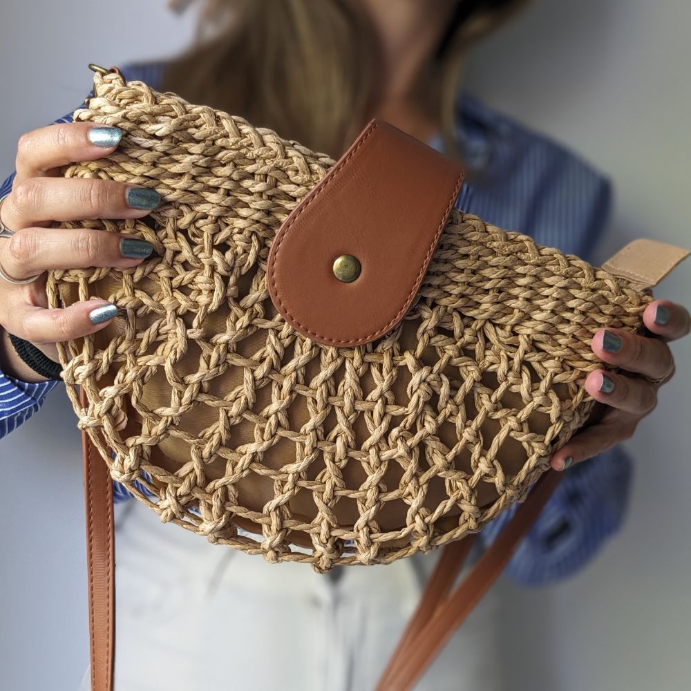 Chic beige braided straw shoulder bag with elegant web design, a versatile accessory for summer and casual wear.