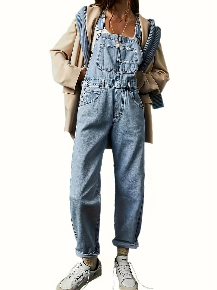 Women's loose fit denim dungarees, casual blue overalls with adjustable straps on model.