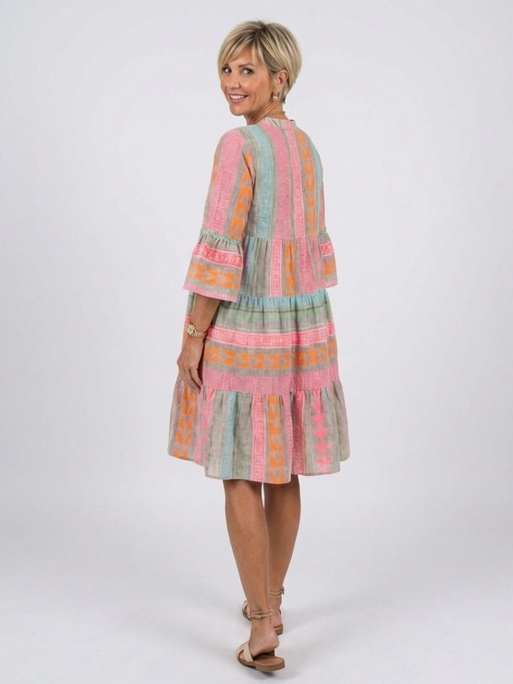 Casual women's day dress: pink geometric print, V-neck, tiered, knee-length, 3/4 sleeves. Great summer fashion.