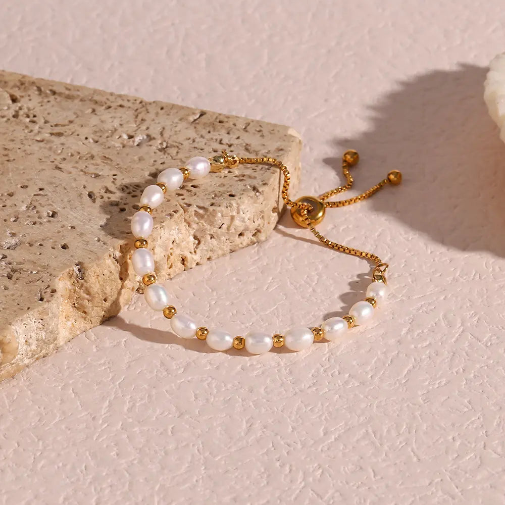 Detailed view of a women's elegant gold bracelet with shimmering pearls, a beautiful accessory.