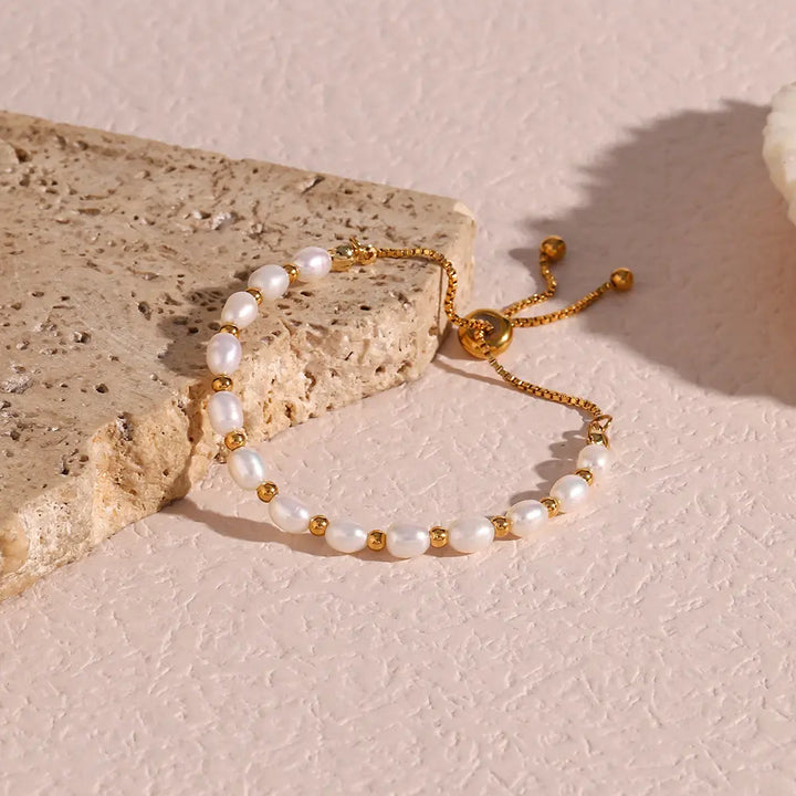 Detailed view of a women's elegant gold bracelet with shimmering pearls, a beautiful accessory.