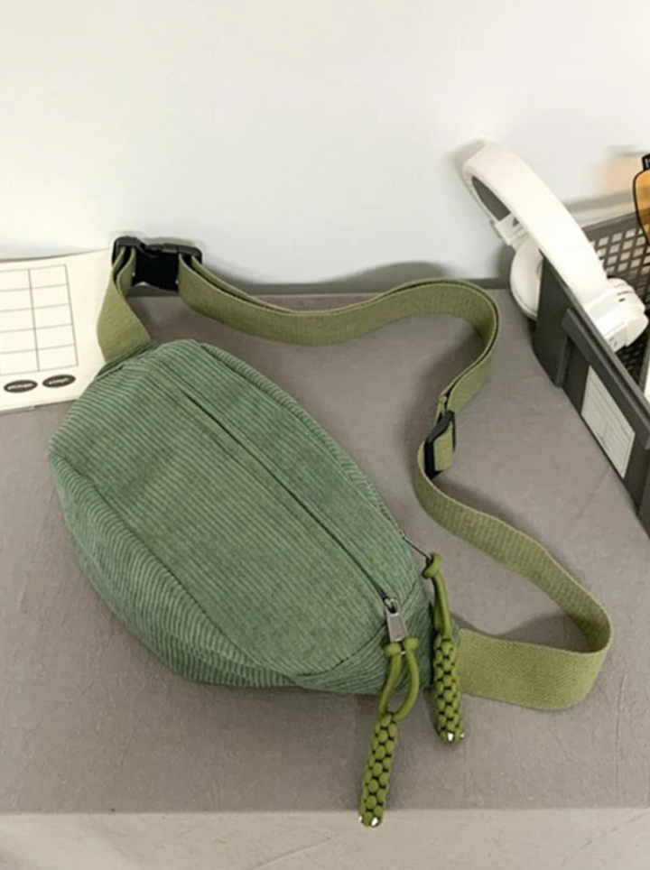Stylish green corduroy hip bag, also worn as a shoulder pouch. Unisex accessory for versatile everyday carry.