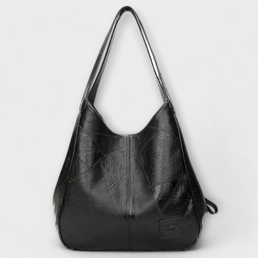 Stylish women's vintage leather shoulder bag with antique brass hardware, a timeless handbag.
