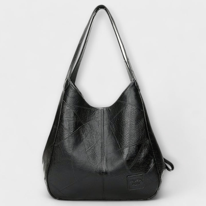 Stylish women's vintage leather shoulder bag with antique brass hardware, a timeless handbag.