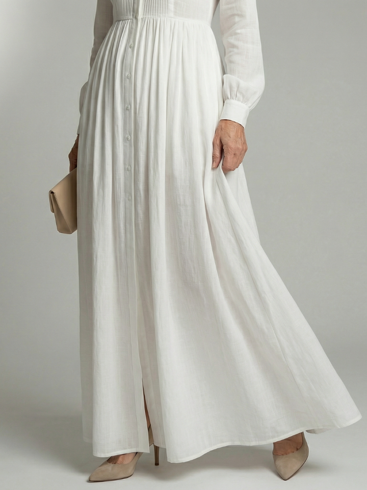 Elegant white maxi dress for women, featuring a soft flowy fabric, long sleeves & stylish button front detail.