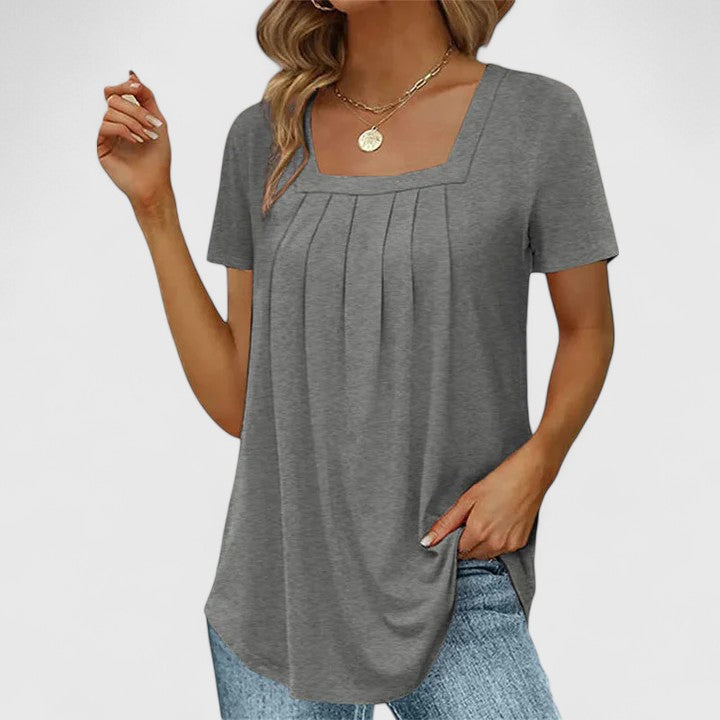 Elegant white summer blouse with square neckline, short sleeves & pleats. Feminine & versatile.