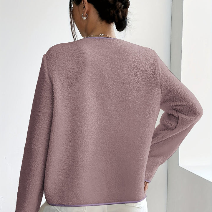 Close-up: Textured elegant women's button-front jacket. Soft, comfortable, timeless autumn-winter fashion.