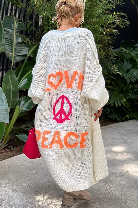 Trendy women's knitwear oversized cardigan, showcasing a vibrant 'Love & Peace' print for a relaxed, boho style.