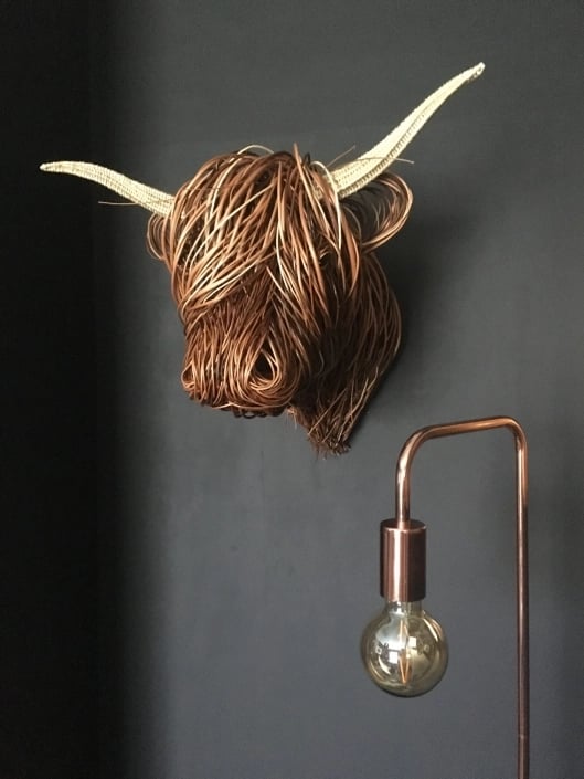 Rustic handwoven rattan Toro wall sculpture, natural texture boho home decor.